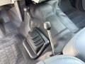 Image shows the gear shift and control lever of a 2012 Ford F-450 SD with a textured floor mat beneath