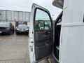 A 2020 Chevrolet Express with its driver's side door open showing the interior details and seating area