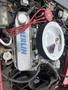 An engine with a polished chrome air filter and red spark plug wires prominently featuring the name "MERLIN" on the valve cover