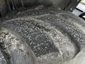 Close-up of a worn tire with deep treads showing dirt and debris on its surface