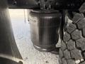 A black air suspension bag mounted on the chassis of a 2011 International 4300 truck with visible texture and details of the bag and nearby tire