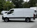 A 2020 Mercedes-Benz Sprinter van with a white exterior and black accents is shown in profile view, featuring smooth lines and a spacious cargo area