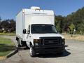 A white 2013 Ford Econoline box truck with a black grille and large cargo area on the back facing forward