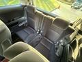 The image shows the interior of a 2009 Toyota Vellfire featuring a spacious rear seating arrangement with black upholstery and seatbelts