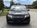 A black 2014 Honda Odyssey seen from the front with distinct headlights and a centered Honda emblem on the grille