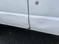 A white 2008 Ford Econoline with visible scratches and a dent on the side panel