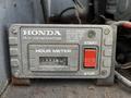 A Honda R.V generator control panel featuring an hour meter display and a red start button alongside a stop button