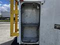 An empty storage compartment of a 2008 Ford F-550 with metal walls and a single shelf inside