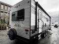 A 2022 Aspen Trail travel trailer featuring a metallic exterior with the brand name visible and two wheels at the base