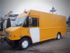 A yellow 2008 Freightliner MT45 Chassis with a tall cargo area and a white side door parked at an angle showcasing its front features and wheels