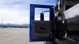 A blue door of a 2012 International DuraStar 4300 truck is opened revealing the interior and side mirror