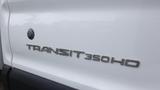 Close-up of the badge on a 2018 Ford Transit 350 HD displayed in white with water droplets on the surface