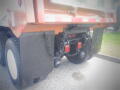 A 2016 International WorkStar 7500 truck with large black fenders and visible red and clear tail lights