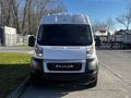 A 2021 RAM Promaster van facing forward with a white exterior and prominent black grille displaying the RAM logo