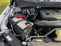 A 2021 Ford F-150 engine bay showing the battery and various components with wires and hoses visible