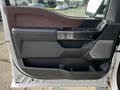 A 2021 Ford F-150 truck door with a modern design featuring a brown and black interior trim and a speaker grill