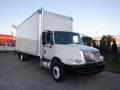 A 2014 International Durastar truck with a white cargo box and a black front bumper parked at an angle