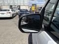 A close-up view of the side mirror of a 2021 Ford Transit Connect with raindrops on the surface