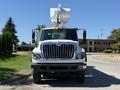 A 2013 International 7400 bucket truck with a white and black exterior and a large articulated arm mounted on top