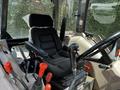 The interior of a 2011 Kubota M8540D tractor featuring a black driver's seat with armrests and various controls visible around the seat