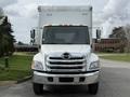 A white 2017 Hino 338 box truck facing forward with a chrome grille and orange clearance lights on the roof