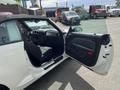 A white 2005 Chrysler PT Cruiser with an open driver's door revealing the interior featuring a black seat and dashboard