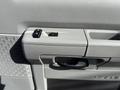 Close-up of the door panel of a 2023 Ford E-450 featuring window controls and a door handle