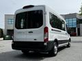 A 2022 Ford Transit van with a white exterior and large rear windows showcasing its spacious design and modern features