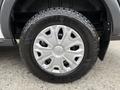 A close-up of a Goodyear tire mounted on a silver wheel of a 2017 Ford Transit T150 XLT with five spokes and a smooth center cap