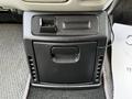A dark-colored center console with compartments and an open storage area in a 2003 Mitsubishi Delica
