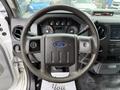 Steering wheel of a 2015 Ford F-350 SD with the Ford logo visible and dashboard controls in the background