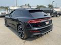 A 2020 Audi RS Q8 in black with a sporty design featuring dual exhausts and sleek body lines