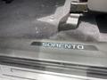 A close-up of the driver-side door sill of a 2015 Kia Sorento displaying the nameplate Sorento in silver lettering on a black surface