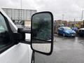 A close-up view of the side mirror of a 2015 GMC Sierra 1500 showing raindrops on its surface