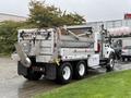 A 2011 International 7500 truck with a large rear dump bed and a mounted chute for unloading materials