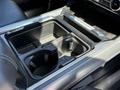 Center console of a 2024 Ford F-550 Super Duty featuring two cup holders and a plastic insert for storage