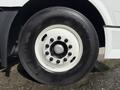 A close-up view of the wheel of a 2012 Volvo VNL showing a black tire with a white rim and multiple lug nuts