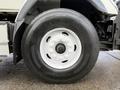 A close-up of a large black tire mounted on a white rim attached to a 2016 International 7400 truck