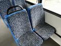 A blue and patterned fabric bus seat with a black handle