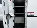 Interior of a 2013 Ford F-650 truck showing open access with shelves inside and a warning sign attached to the door