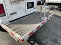 A 2008 Ford Econoline with a flatbed trailer featuring a diamond plate surface and a small metal post on one side