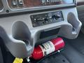 Interior dashboard of a 2016 Freightliner M2 106 featuring cup holders climate controls and a mounted fire extinguisher