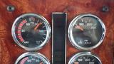 The dashboard of a 2003 International 5600i featuring four round gauges displaying air pressure and temperature readings