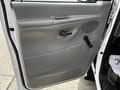 A close-up view of the interior door panel of a 2004 Ford Econoline featuring a door handle and a window crank