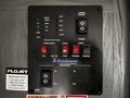 Control panel for a 2022 Aspen Trail featuring switches for water heater, lights, awning retract, gas and electric settings, along with labels for tank levels and slide rooms