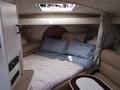 A cozy sleeping area in a 1991 Larson Mirado featuring a bed with blue and beige bedding and soft pillows