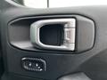 Interior door handle of a 2019 Jeep Wrangler featuring a silver finish and a black button for locking and unlocking the door