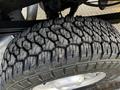 Close-up of a rugged tire with an aggressive tread pattern mounted on a 2012 Ford F-250 showing wear and details in the rubber design