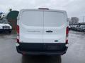 Rear view of a white 2018 Ford Transit 250 van with a flat tailgate and no visible rear license plate