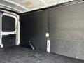 Interior of a 2022 Ford Transit van featuring a spacious cargo area with black paneling and a flat rubber floor